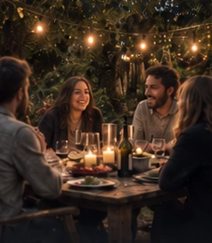 Friends around a candlelit table beneath garden lights